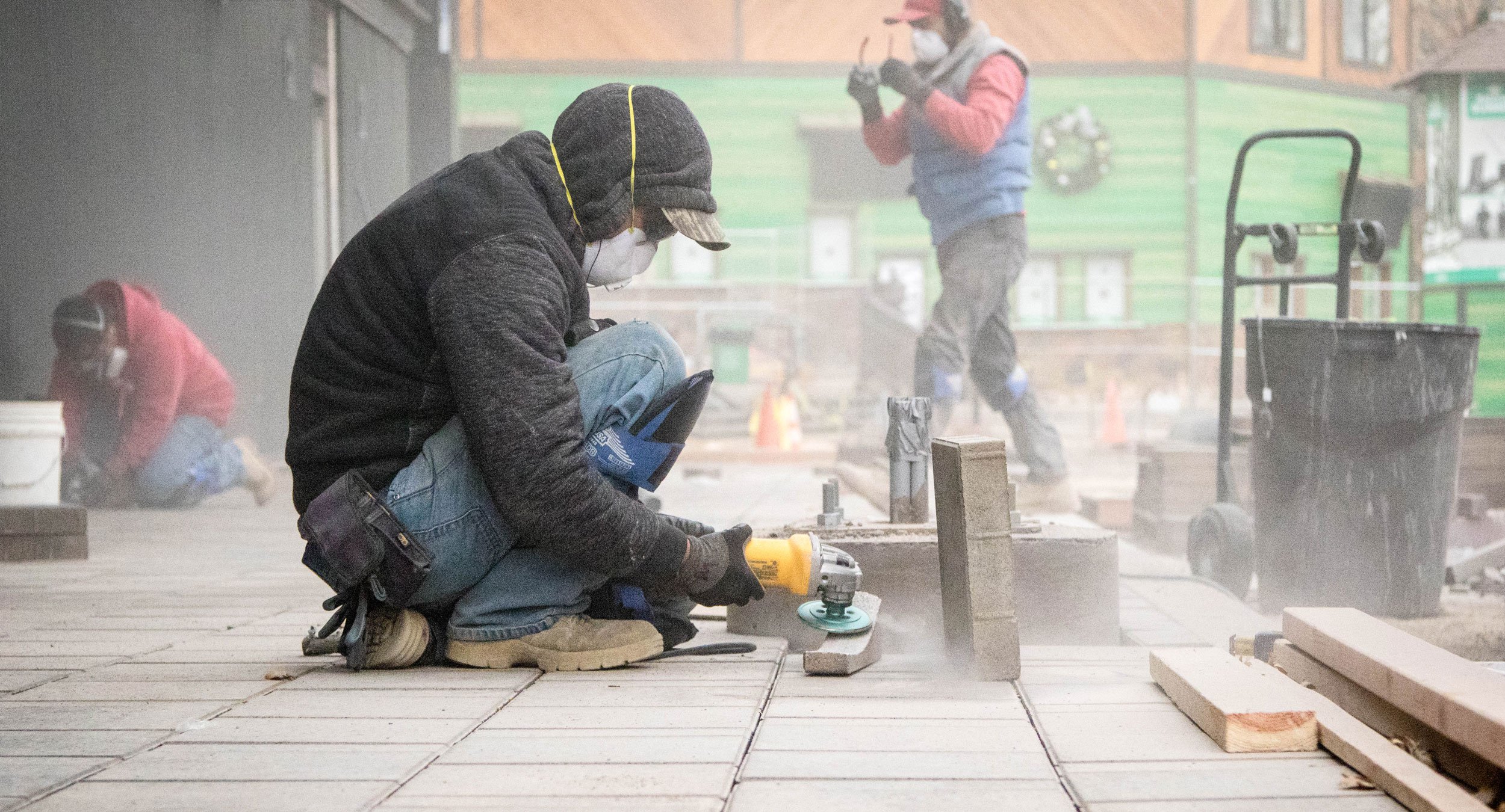 Construction workers working outdoors on a parking lot sidewalk